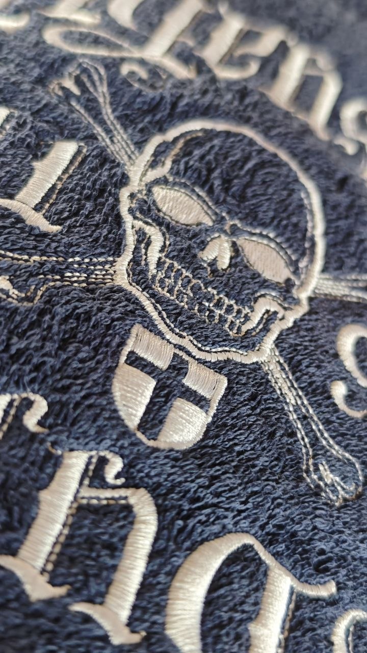 Detailreiche Motivstickerei auf blauem Handtuch