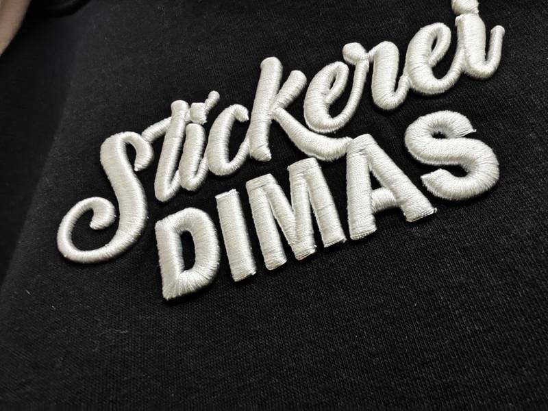 3D-Stickerei weiß auf schwarz, Stickerei DIMAS erhabene Schrift Wien