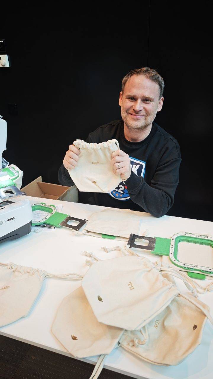 Alessandro zeigt bestickte Beutel, Event-Stickerei Personalisierung Wien