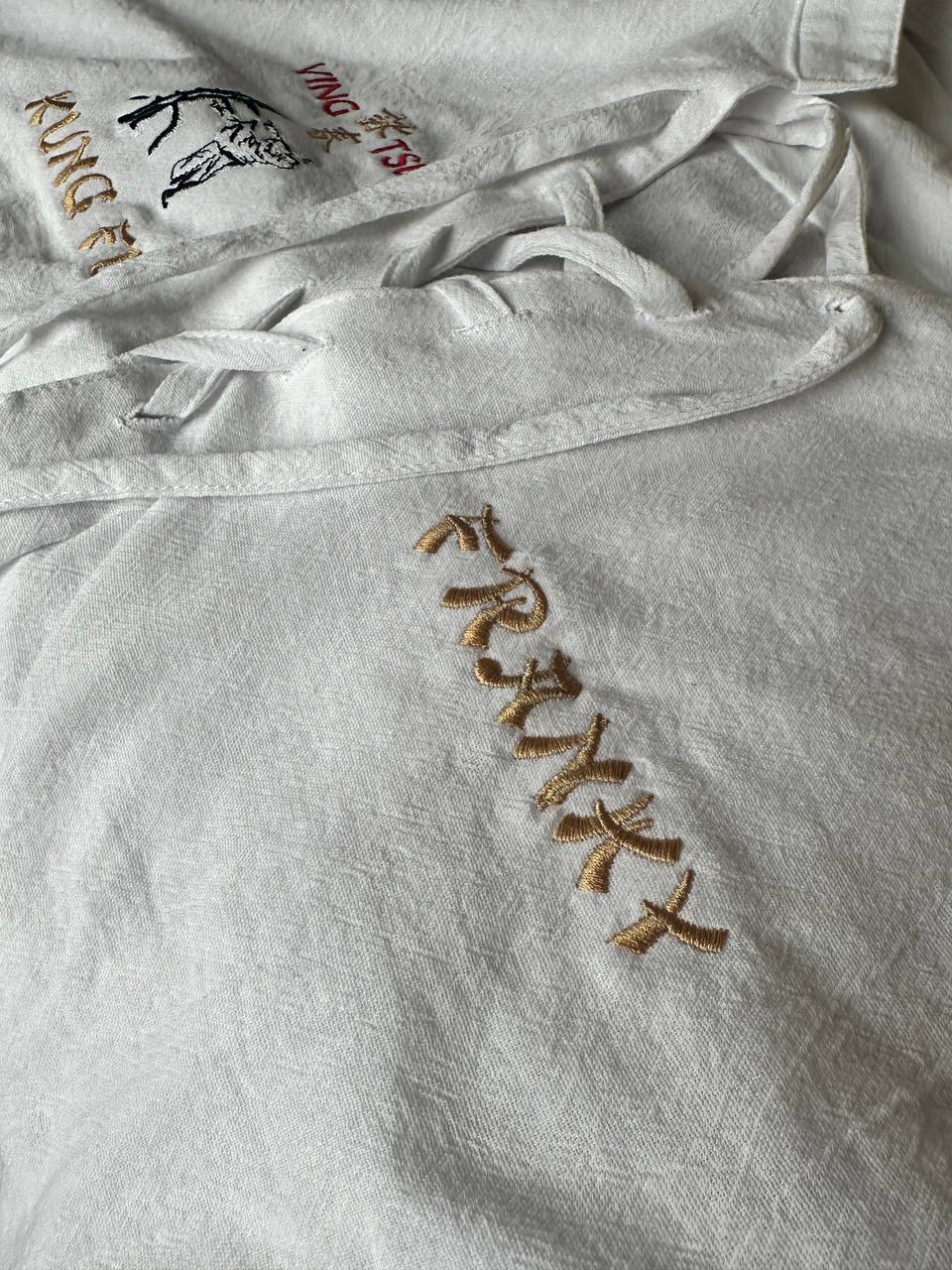 Goldenes Monogramm Franky auf weißem Hemd bestickt von der Wiener Stickerei