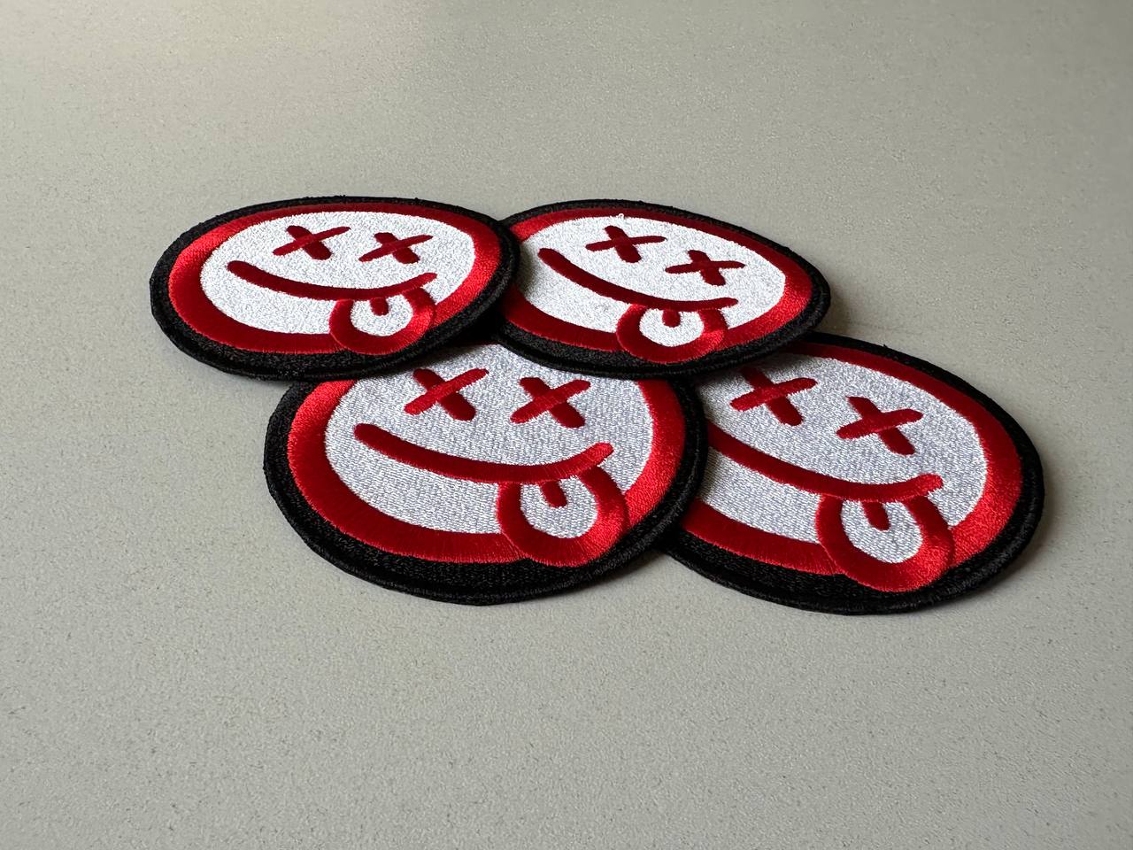 Vier gestickte Smiley Aufnäher in Rot, Weiß und Schwarz mit X Augen