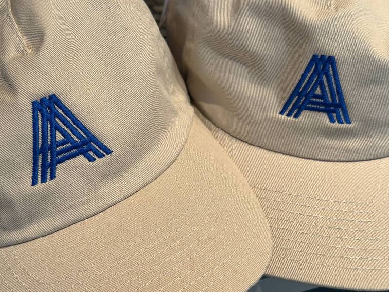 Beige Kappen mit blauem Logo bestickt, Kappenstickerei Serien Wien