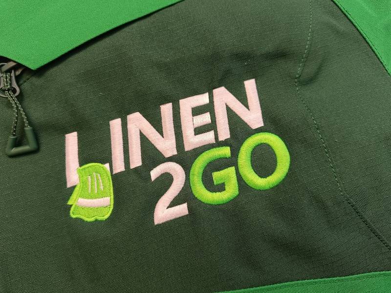 Linen2Go Logo gestickt auf grüner Jacke, Firmenstickerei Wien