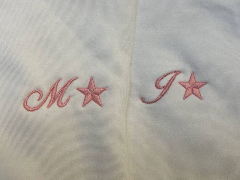 Monogramm mit Stern auf Babykleidung, Rosa Stickerei Wien