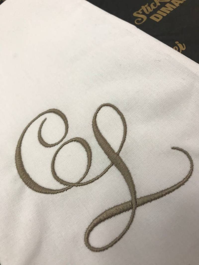 Elegantes Monogramm auf weißem Stoff gestickt, Initialen Wien