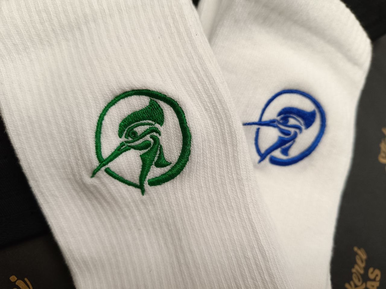 Weiße Socken bestickt, Logo Sockenstickerei Wien