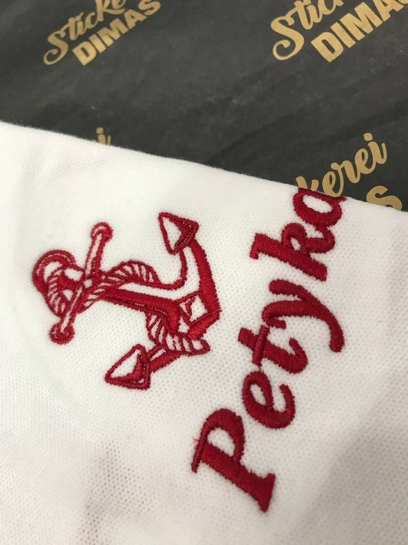 Petyka Logo und Anker auf weißem Poloshirt gestickt, Logostickerei Wien