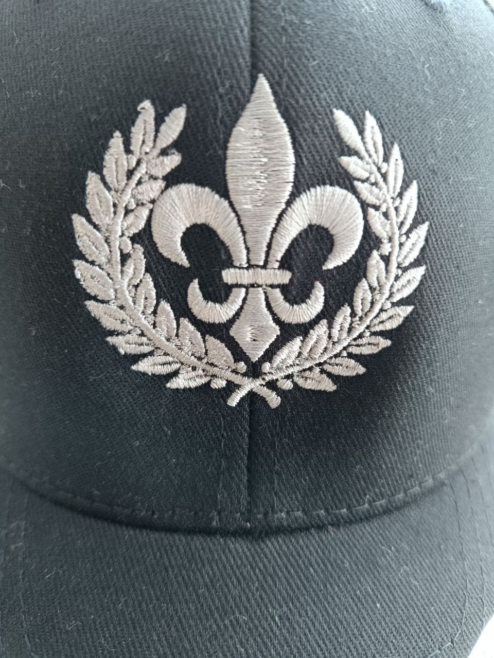 Gesticktes Wappen-Detail auf schwarzer Kappe, Nahaufnahme