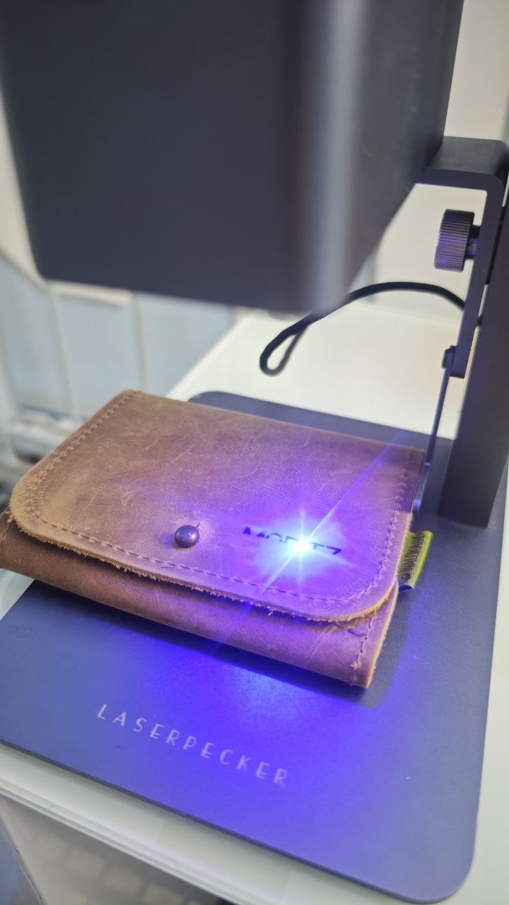 Lasergravur einer Ledergeldbörse während der Bearbeitung in der Werkstatt Wien
